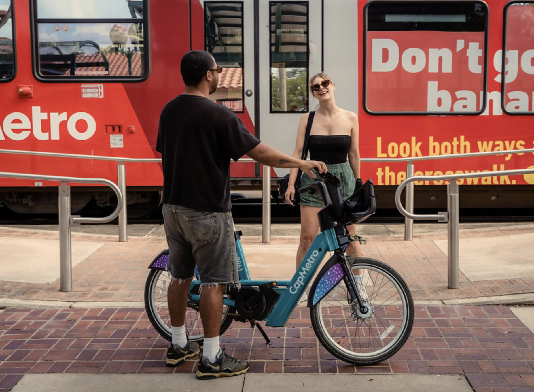 CapMetro Bikeshare in front of CapMetro Rail Festival goers riding CapMetro Bikeshare in front of CapMetro Rail