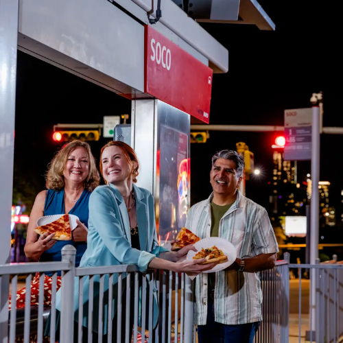 People enjoying home slice pizza at the soco bus stop
