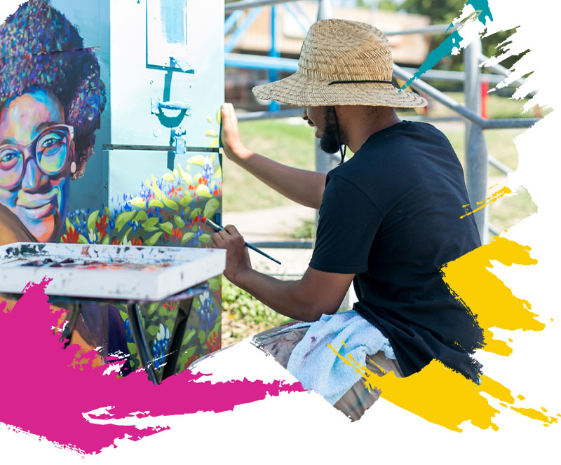 Image of artist painting mural on a power box.